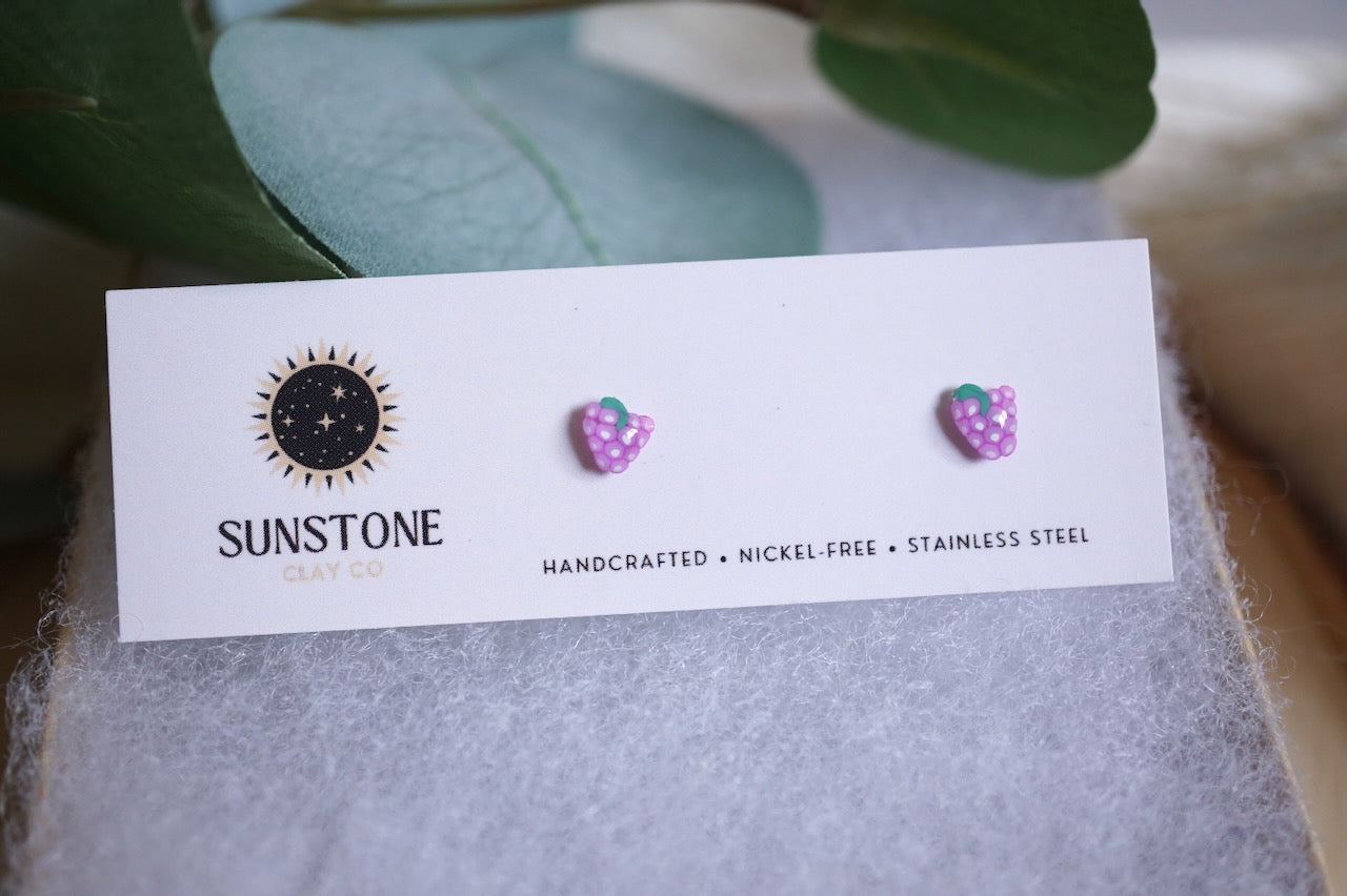 Handcrafted mini grape stud earrings on Sunstone Clay Co display card
