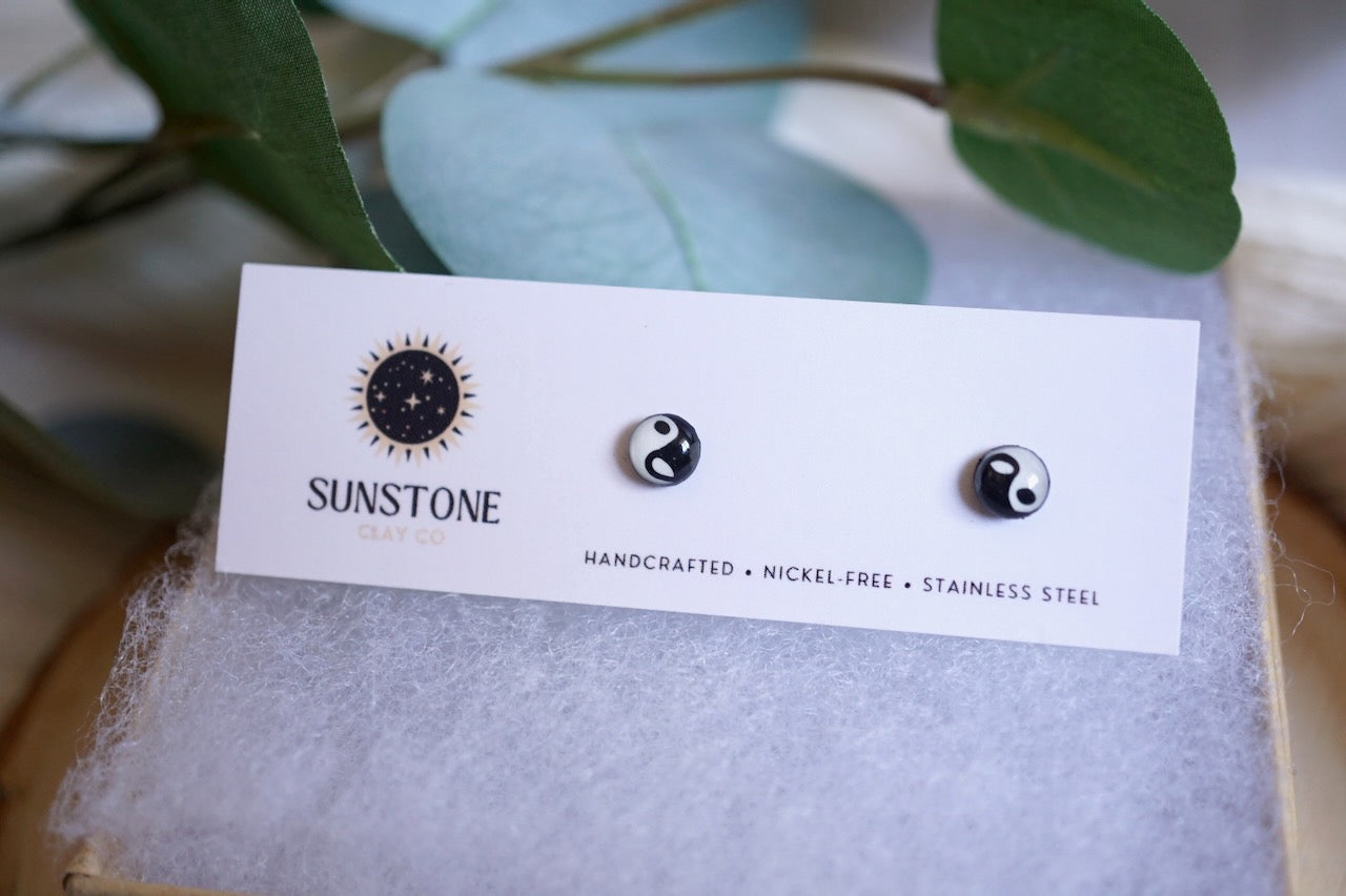 Handcrafted black and white Yin Yang stud earrings on Sunstone Clay Co display card