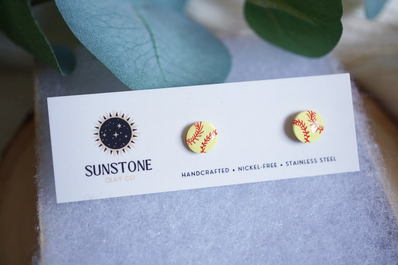 Softball stud earrings on a branded Sunstone Clay Co display card