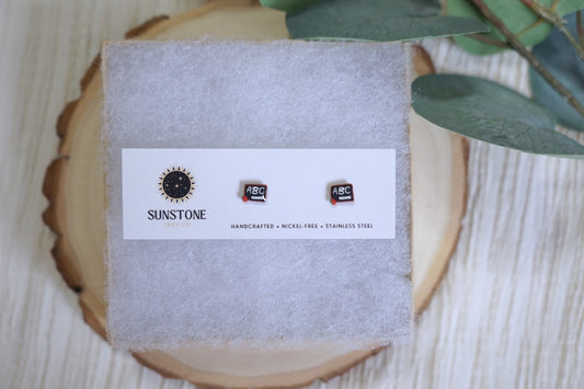Mini chalkboard stud earrings with apple and chalk details on Sunstone Clay Co card