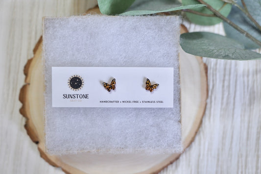 Butterfly earrings on a branded card with a natural background