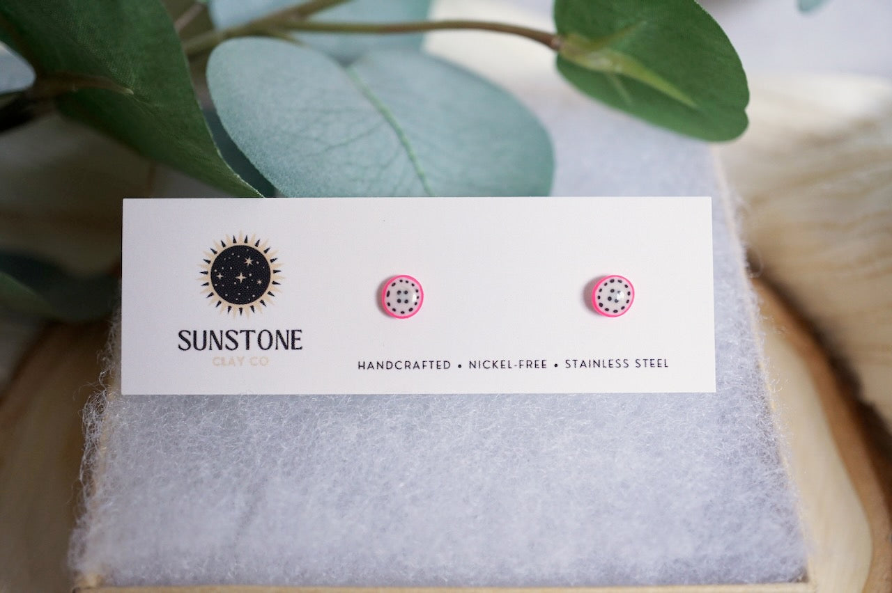 Small handmade dragon fruit slice stud earrings displayed on Sunstone Clay Co card.