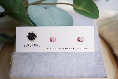 Small handmade dragon fruit slice stud earrings displayed on Sunstone Clay Co card.