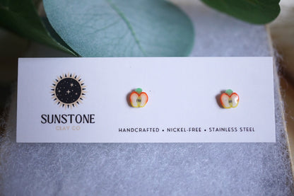 Mini apple slice stud earrings on Sunstone Clay Co. display card