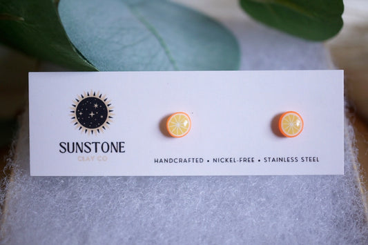 Mini citrus orange polymer clay earrings on branded earring card