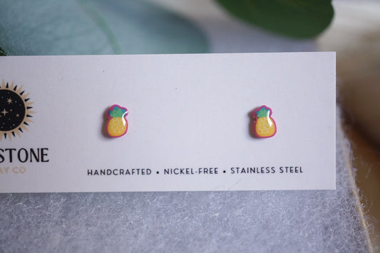 Handcrafted pineapple stud earrings on Sunstone Clay Co display card