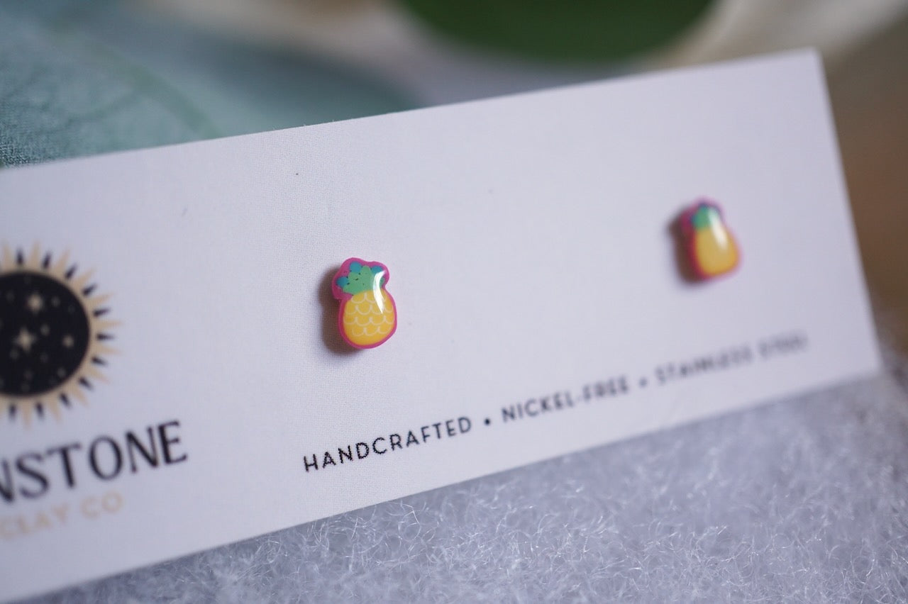 Handcrafted pineapple stud earrings on Sunstone Clay Co display card