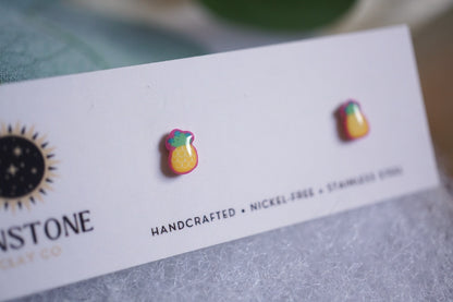 Handcrafted pineapple stud earrings on Sunstone Clay Co display card