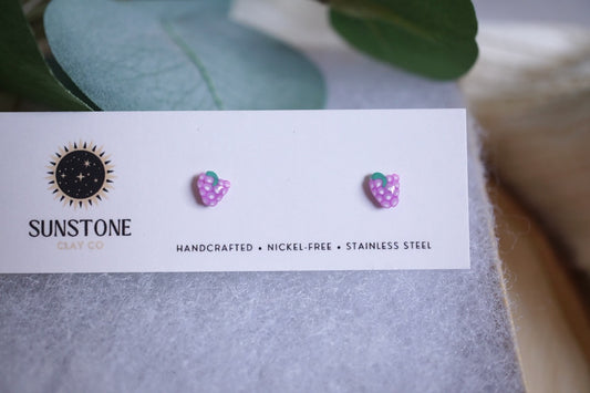 Handcrafted mini grape stud earrings on Sunstone Clay Co display card