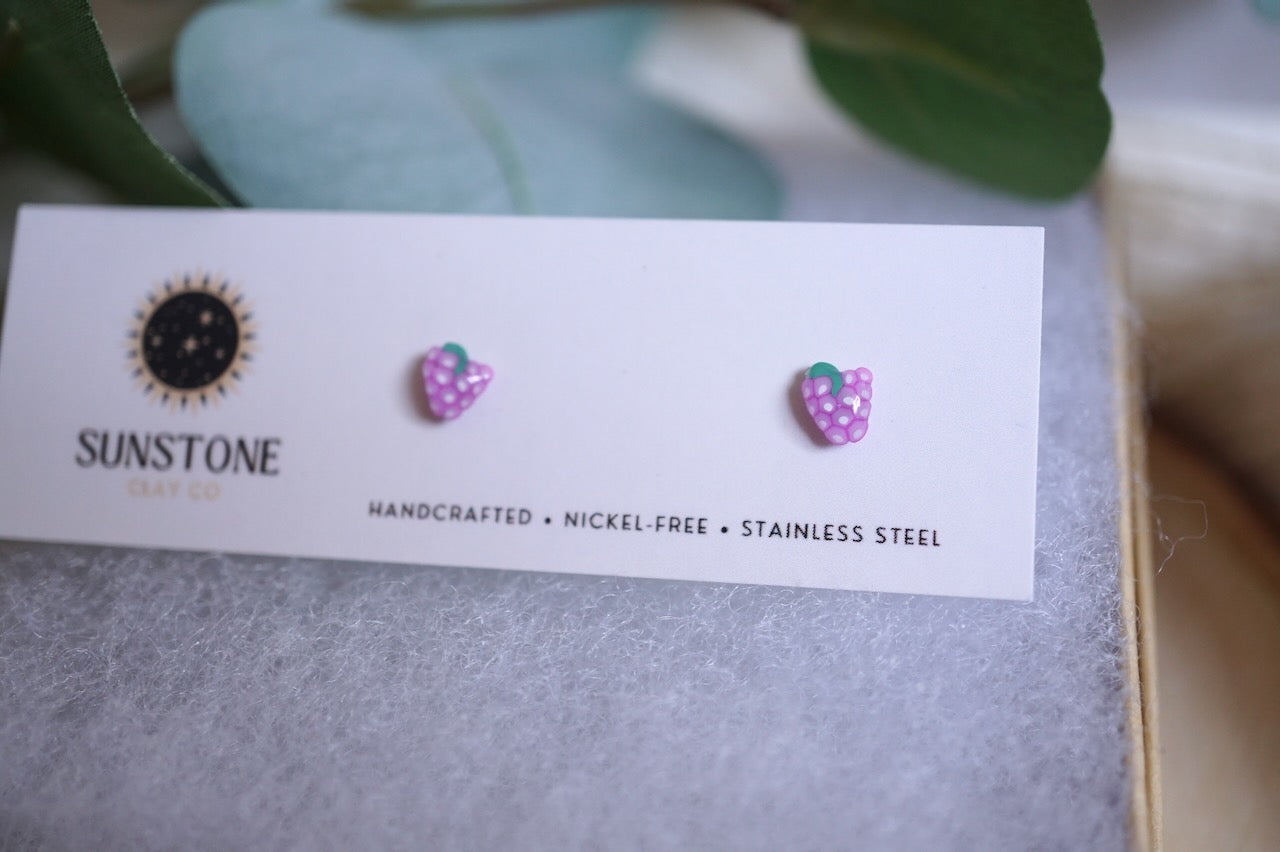 Handcrafted mini grape stud earrings on Sunstone Clay Co display card