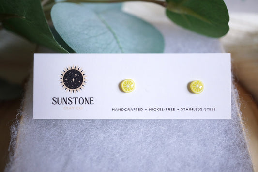 Handcrafted lemon slice stud earrings on Sunstone Clay Co. card