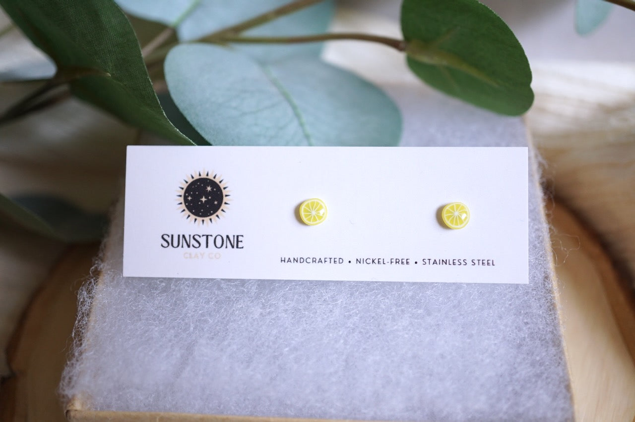 Handcrafted lemon slice stud earrings on Sunstone Clay Co. card