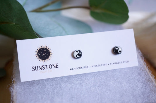 Handcrafted black and white Yin Yang stud earrings on Sunstone Clay Co display card