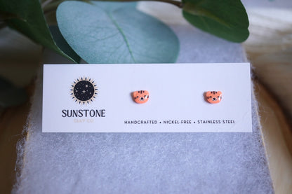 Handcrafted polymer clay tiger face stud earrings displayed on a jewelry card