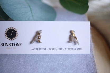 Pair of gold and gray earrings on a branded card with 'Sunstone' logo and text.