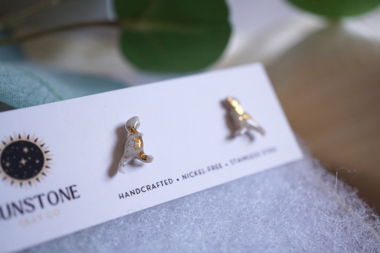 Pair of gold and gray earrings on a Sunstone Clay Co branded card with a blurred background