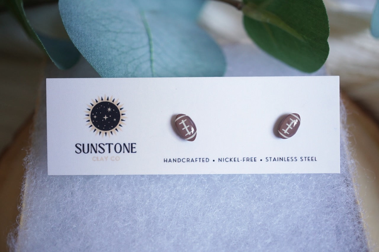Handcrafted football stud earrings from Sunstone Clay Co. Small-batch polymer clay minis with hypoallergenic stainless steel posts. Perfect for sports lovers, gifts, and game-day style.