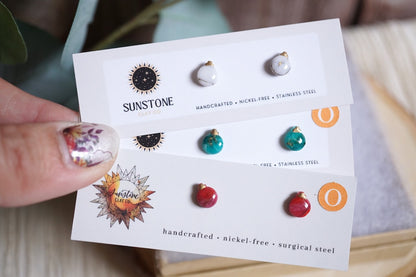 Small handcrafted ornament earrings in white, green, and red options.