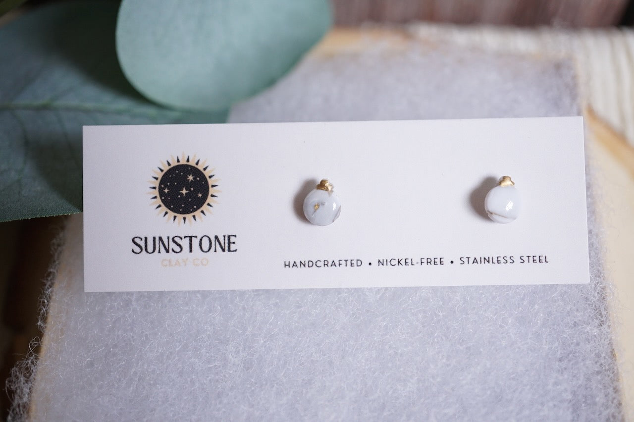 Small handcrafted ornament earrings in white.