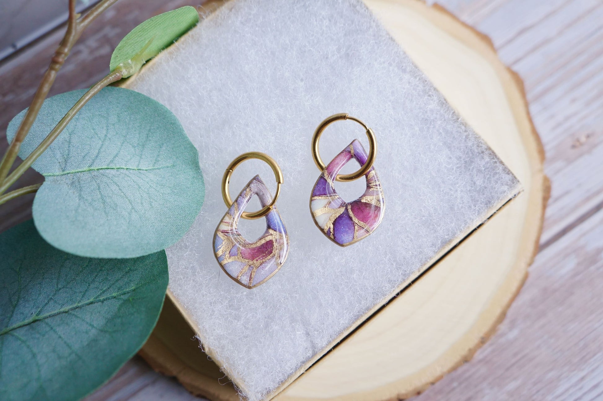 Lightweight blush statement earrings on neutral display