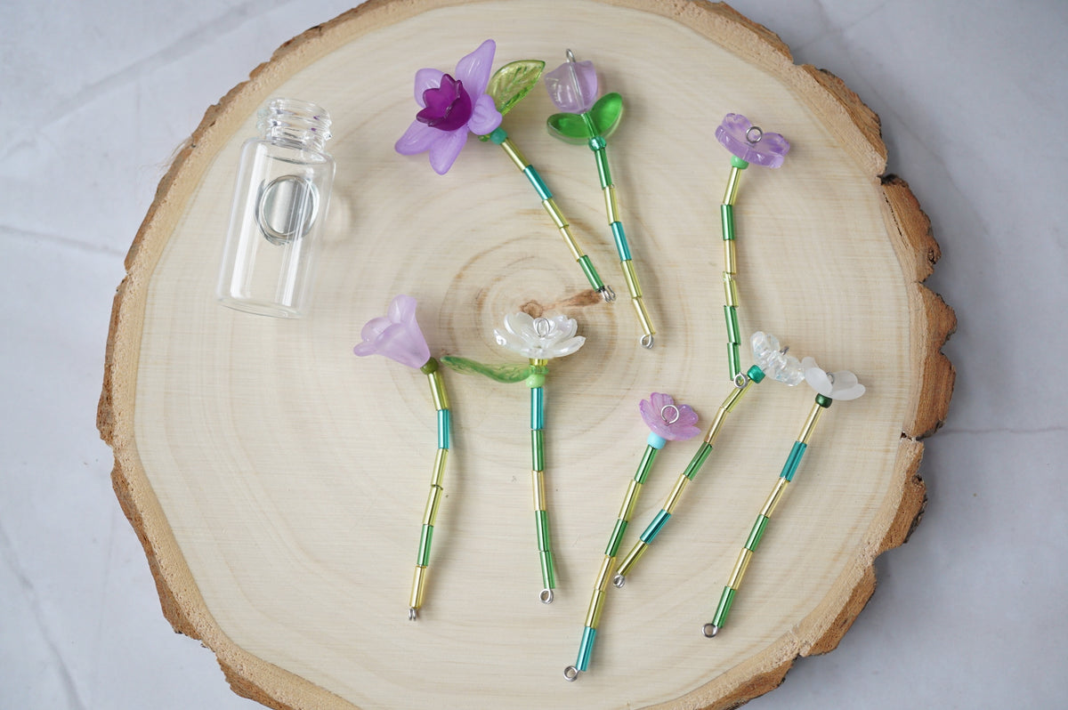Forever flowers laid out in individual stems, with the clear magnetic vase emptied