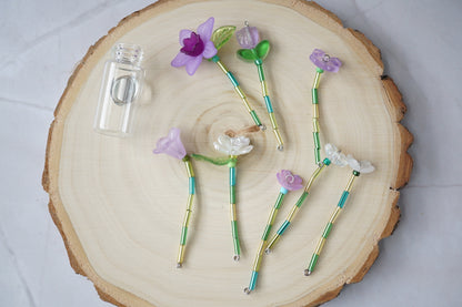 Forever flowers laid out in individual stems, with the clear magnetic vase emptied